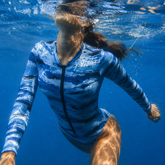 Woman swimming underwater wearing a Kamysh Blue Camo Bodysuit 